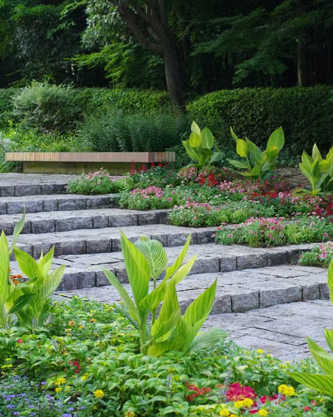 Stone garden steps bordered by seasonal flower beds