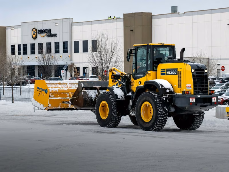 Terravian wheel loader with a containment pusher clearing snow from a distribution-center lot